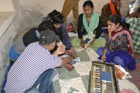 समुह में ढ़ोलक के टुकड़ो को बनाते हुए